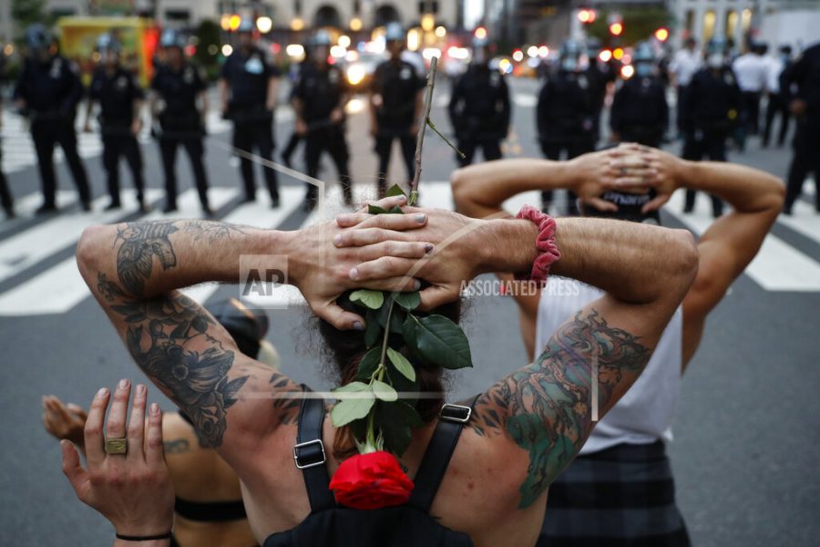 Protesters kneel in front of New York City Police Department officers before being arrested for violating curfew beside the iconic Plaza Hotel on 59th Street, Wednesday, June 3, 2020, in New York. Protests continued following the death of George Floyd, who died after being restrained by Minneapolis police officers on May 25. (AP Photo/John Minchillo)