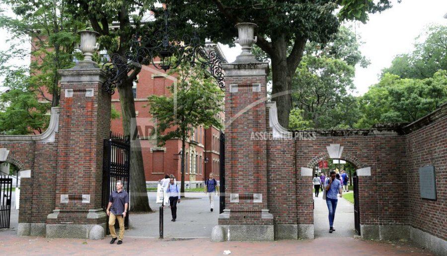 FILE - In this Aug. 13, 2019, file photo, pedestrians walk through the gates of Harvard Yard at Harvard University in Cambridge, Mass. Harvard and the Massachusetts Institute of Technology filed a federal lawsuit Wednesday, July 8, 2020, challenging the Trump administrations decision to bar international students from staying in the U.S. if they take classes entirely online this fall. Some institutions, including Harvard, have announced that all instruction will be offered remotely in the fall during the ongoing coronavirus pandemic. (AP Photo/Charles Krupa, File)