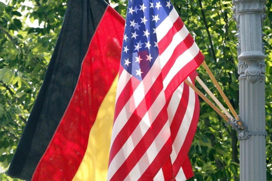 FILE - In this June 6, 2011 file photo, the German and U.S. flags fly on a lamp post in front of the White House in Washington ahead of German Chancellor Angela Merkels visit. Defense officials say the U.S. will pull 12,000 troops from Germany, bringing 6,400 forces home and shifting 5,600 to other countries in Europe, including Italy and Belgium. The plan will cost billions of dollars and take years to complete. (AP Photo/Charles Dharapak)