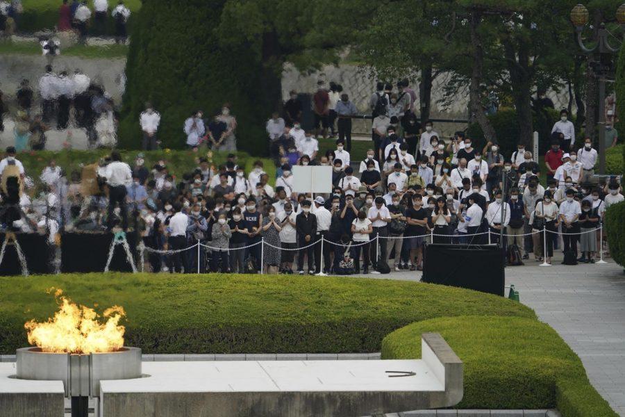Visitors observe a minute of silence for the victims of the atomic bombing, at 8:15am, the time atomic bomb exploded over the city, at the Hiroshima Peace Memorial Park during the ceremony to mark the 75th anniversary of the bombing Thursday, Aug. 6, 2020, in Hiroshima, western Japan. (AP Photo/Eugene Hoshiko)
