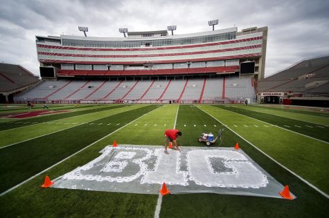 FILE - In this Thursday, Oct. 6, 2011 file photo, turf manager Jared Hertzel touches up the newly-painted Big Ten conference logo on the football field at Memorial Stadium in Lincoln, Neb. Big Ten is going to give fall football a shot after all. Less than five weeks after pushing football and other fall sports to spring in the name of player safety during the pandemic, the conference changed course Wednesday and said it plans to begin its season the weekend of Oct. 23-24. (Jacob Hannah/Lincoln Journal Star via AP, File)