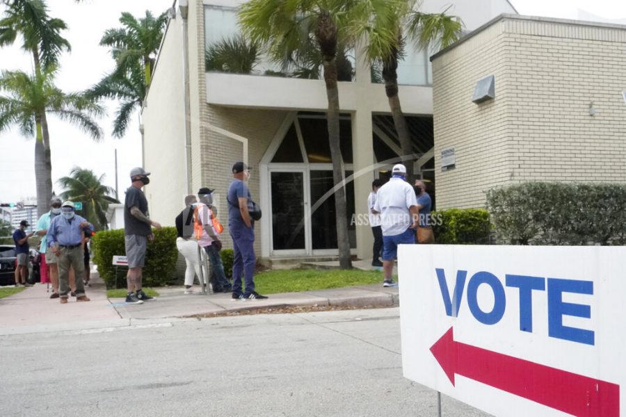 People wait in line to vote outside of an early voting site, Tuesday, Oct. 20, 2020, in Miami Beach, Fla. Florida began in-person early voting in much of the state Monday. With its 29 electoral votes, Florida is crucial to both candidates in order to win the White House. (AP Photo/Wilfredo Lee)