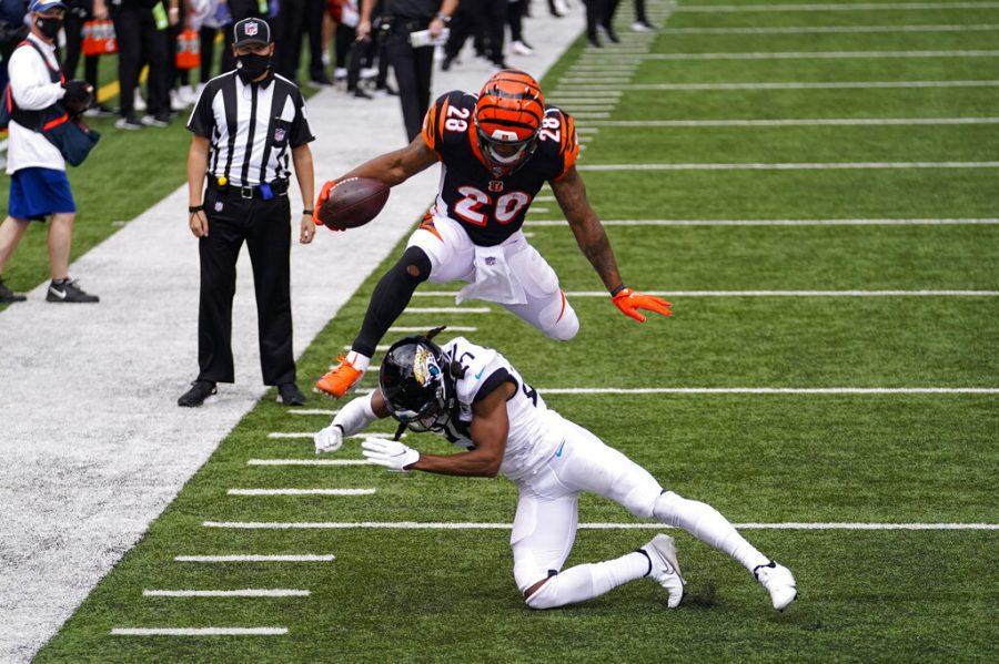 Cincinnati Bengals running back Joe Mixon (28) leaps over Jacksonville Jaguars cornerback Chris Claybrooks (27) for a touchdown in the first half of an NFL football game in Cincinnati, Sunday, Oct. 4, 2020. (AP Photo/Bryan Woolston)