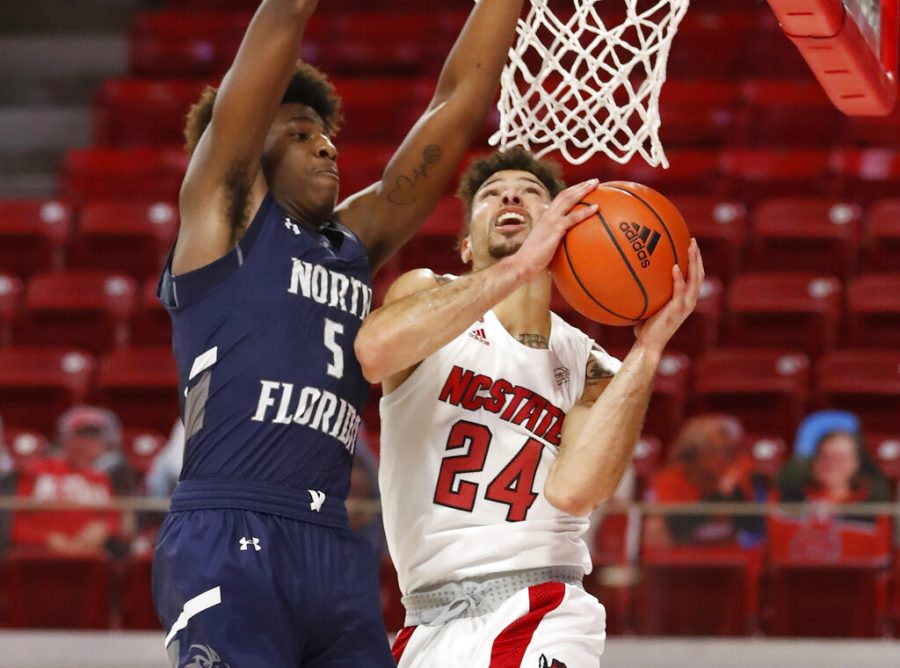 North Carolina State's Devon Daniels (24) shoots as North Florida's Dorian James (5) defends during the first half during the first half of an NCAA college basketball game at Reynolds Coliseum in Raleigh, N.C., Friday, Nov. 27, 2020. (Ethan Hyman/The News &amp; Observer via AP)