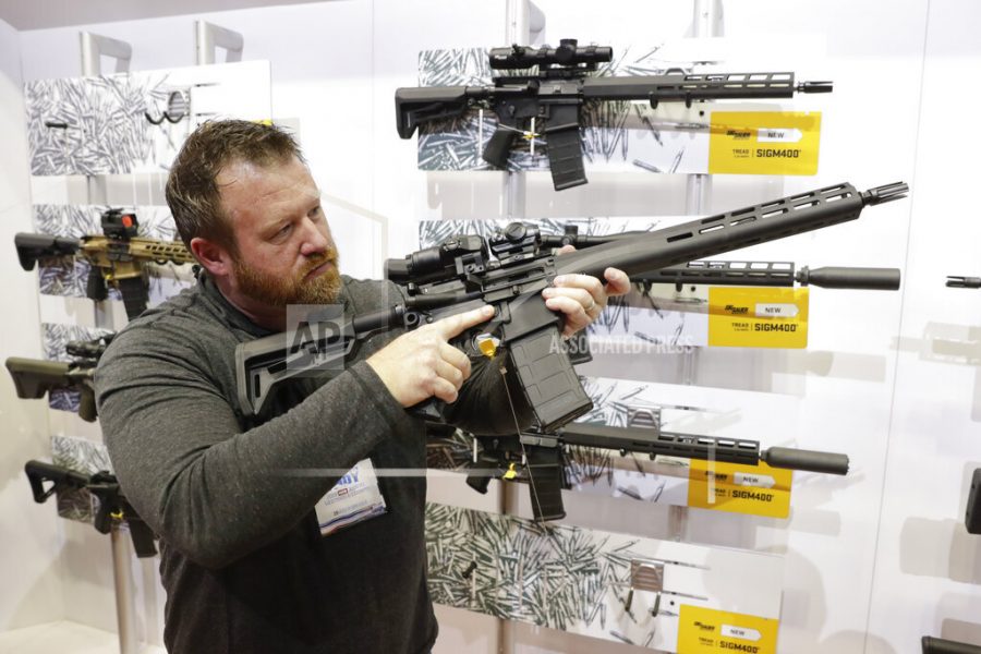 FILE - Bryan Oberc, Munster, Ind., tries out an AR-15 from Sig Sauer in the exhibition hall at the National Rifle Association Annual Meeting in Indianapolis, Saturday, April 27, 2019. Efforts to impose restrictions on firearms will soon have a supporter in the White House. But its unlikely that big ticket items gun-control advocates have pined for will have much chance of passage given the tight margins in Congress and the increased polarization over gun issues. Much has changed in the past 12 years: more Americans own firearms and there are more AR-platform firearms in the civilian market. (AP Photo/Michael Conroy)