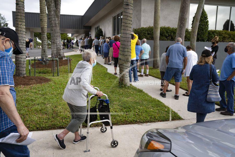 Seniors stand in line to make an appointment to receive the Moderna COVID-19 vaccine outside the Kings Point clubhouse in Delray Beach,  Fla., on Wednesday, Dec. 30, 2020. (Greg Lovett /The Palm Beach Post via AP)