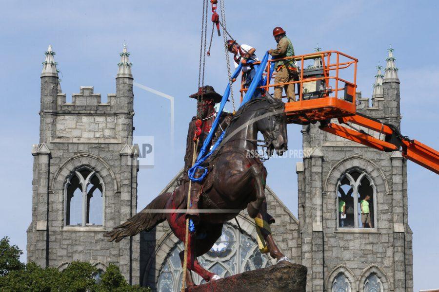 FILE - In this July 7, 2020, file photo, crews attach straps to the statue Confederate General J.E.B. Stuart on Monument Avenue in Richmond, Va. At least 160 Confederate symbols were taken down or moved from public spaces in 2020. Thats according to a new count the Southern Poverty Law Center shared with The Associated Press. (AP Photo/Steve Helber, File)