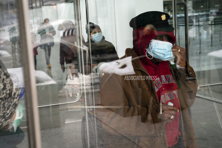 FILE - In this Feb. 3, 2021, file photo, a patient adjusts his face mask as he leaves a COVID-19 vaccination site inside the Jacob K. Javits Convention Center in New York. States are beginning to ease coronavirus restrictions, but health experts say we don’t know enough yet about variants to roll back measures that could help slow their spread. (AP Photo/John Minchillo, File)