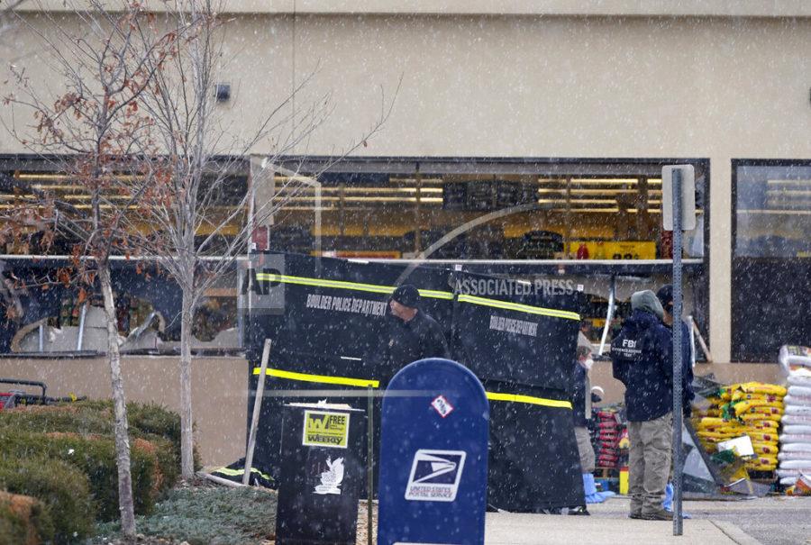 Snow falls as investigators continue to collect evidence in the parking lot where a mass shooting took place at a King Soopers grocery store Tuesday, March 23, 2021, in Boulder, Colo. (AP Photo/David Zalubowski)