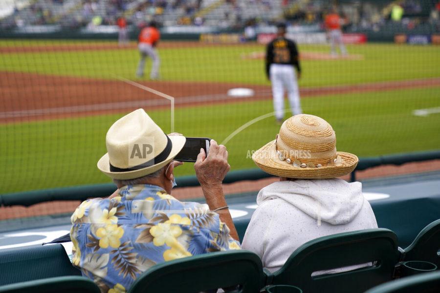 FILE - In this Monday, March 22, 2021 file photo,  two older adults socially distanced, watch a spring training exhibition baseball game between the Pittsburgh Pirates and the Baltimore Orioles in Bradenton, Fla. Spring has arrived with sunshine and warmer temperatures, and many vaccinated seniors are emerging from COVID-19-imposed hibernation. (AP Photo/Gene J. Puskar, File)