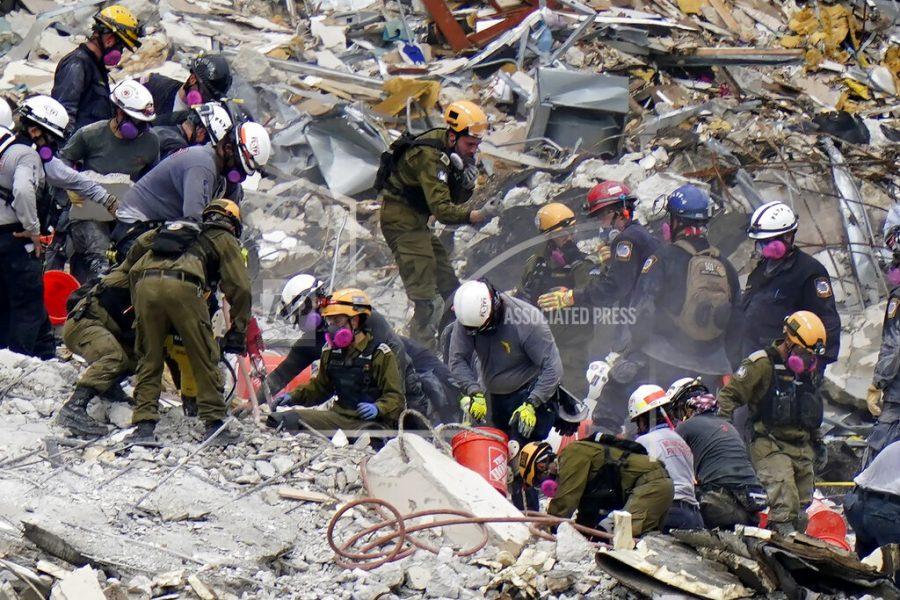 FILE - Crews from the United States and Israel work in the rubble Champlain Towers South condo, Tuesday, June 29, 2021, in Surfside, Fla.  The Israeli search and rescue team that arrived in South Florida shortly after the Champlain Towers South collapsed last month is heading home after an emotional sendoff in Surfside. The team planned to leave Florida on Sunday, July 11. During a brief Saturday evening ceremony, Miami-Dade Mayor Daniella Levine Cava thanked the battalion for their “unrelenting dedication. (AP Photo/Lynne Sladky, File)