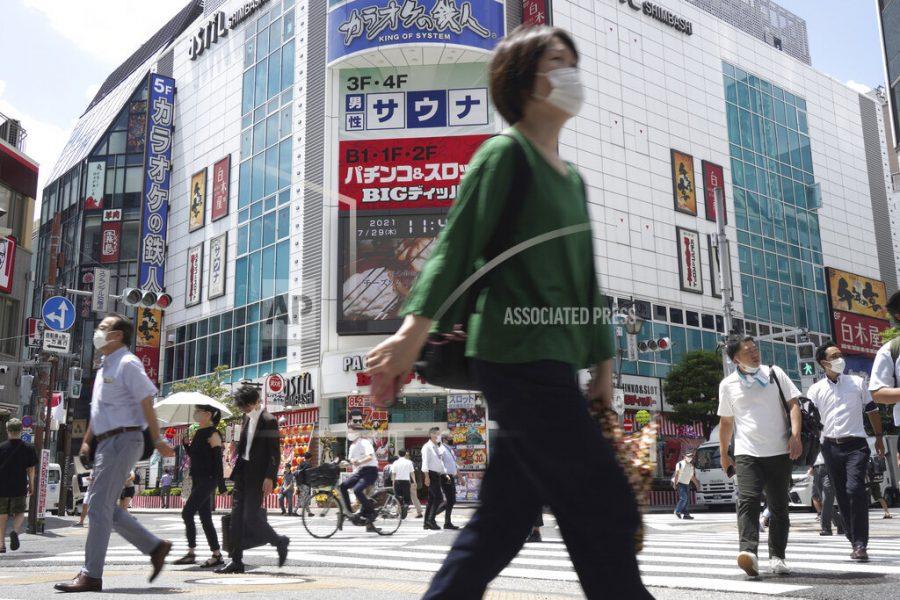 People walk across a crossing near Shimbashi Station in Tokyo Thursday, July 29, 2021, a day after the record-high coronavirus cases were found in the Olympics host city. (AP Photo/Kantaro Komiya)
