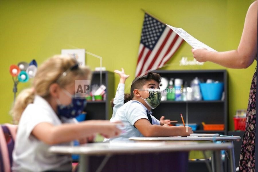 A student listens to the teachers instructions at iPrep Academy on the first day of school, Monday, Aug. 23, 2021, in Miami. Schools in Miami-Dade County opened Monday with a strict mask mandate to guard against coronavirus infections. (AP Photo/Lynne Sladky)