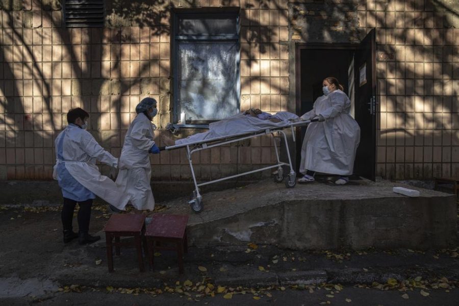 FILE - Medical staff members transport a body of a patient who died of the coronavirus at the morgue of the city hospital 1 in Rivne, Ukraine, Oct. 22, 2021. The global death toll from COVID-19 has topped 5 million, nearly two years into a crisis that has not only devastated poor countries but also humbled wealthy ones with first-rate health care systems. (AP Photo/Evgeniy Maloletka, File)