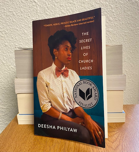 ‘The Secret Lives of Church Ladies’ by Deesha Philyaw stands against a stack of books. 
