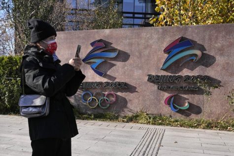 A visitor to the Shougang Park walks past the logos for the Beijing Winter Olympics and Paralympics in Beijing, China, Tuesday, Nov. 9, 2021. China on Monday, Dec. 6, 2021 threatened to take firm countermeasures if the U.S. proceeds with a diplomatic boycott of Februarys Beijing Winter Olympic Games. (AP Photo/Ng Han Guan)