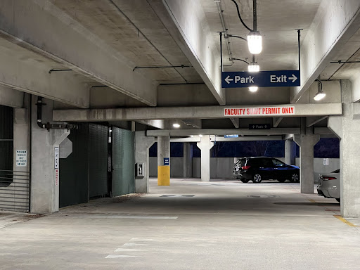 Parked cars sit in the “Faculty and Staff Permit Only” section of the Fine Arts Center Parking Garage (Building 44).