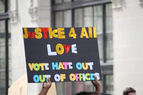 A poster with the message “Justice 4 All Love. Vote Hate Out of Offices” is held up during a Black Lives Matter protest.