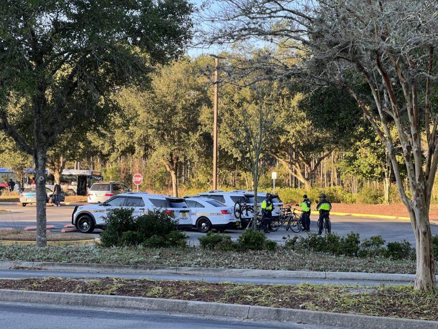 Four police cars sit parked in the parking lot outside the UNF Thomas G. Carpenter Library.