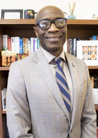 Dr. Richmond Wynn stands for a photo in front of his bookshelf in his Counseling Center office.