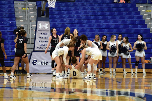 UNF guard Jaida Bond is helped up from the floor by her teammates after being fouled.