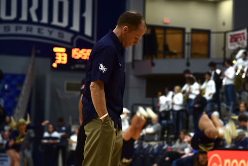 UNF Head Coach Matthew Driscoll walks out to the free throw line, scraping his foot on the floor, as he does at the beginning of every timeout.