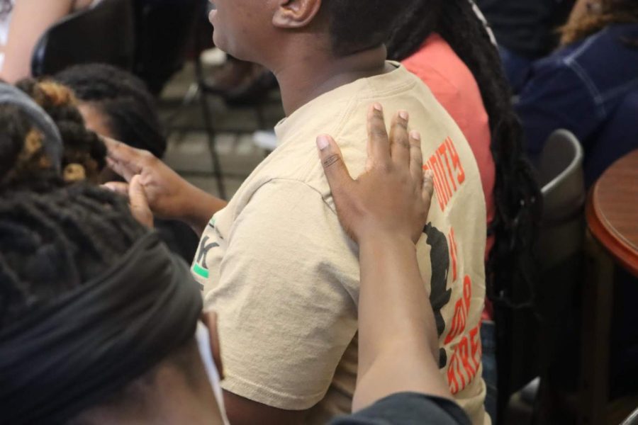 A student puts their hand on another for support