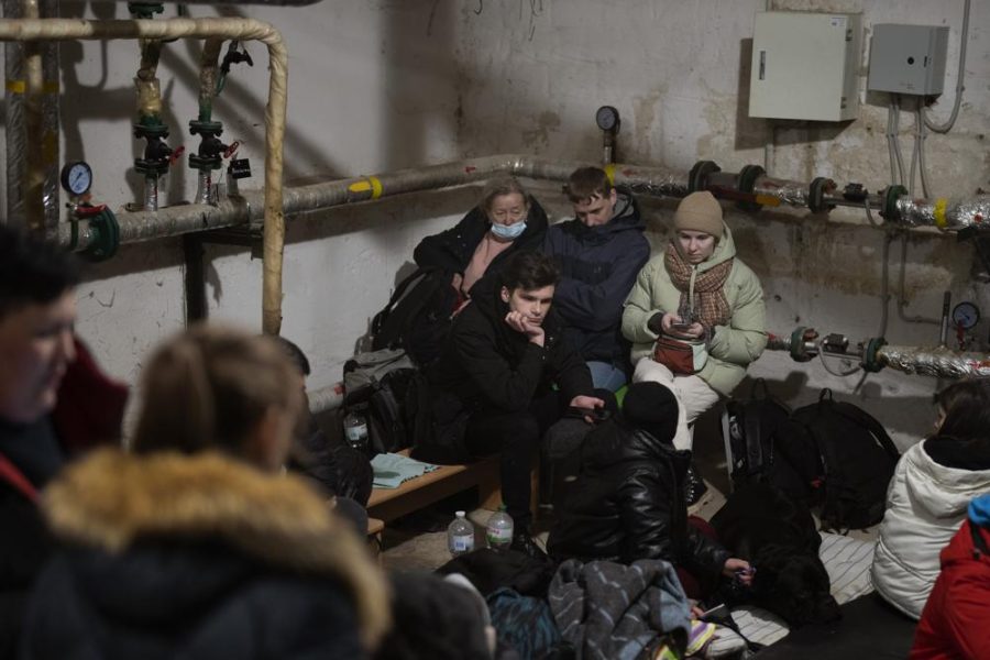 People take shelter at a building basement while the sirens sound announcing new attacks in the city of Kyiv, Ukraine