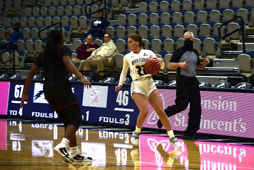 UNF guard Ally Knights brings the ball into the offensive zone, scanning the perimeter for any open teammates.