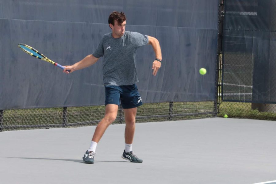 UNF Mens Tennis Matt Carrol getting ready to smack the tennis ball at UNF Tennis Complex in Jacksonville, Florida on March 14, 2022.