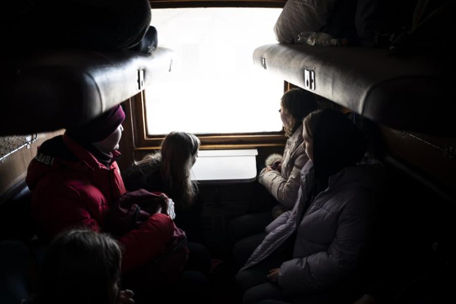 A family escaping from the besieged city of Mariupol along with passengers from Zaporizhzhia onboard a train bound for Lviv, western Ukraine, on Sunday, March 20, 2022.