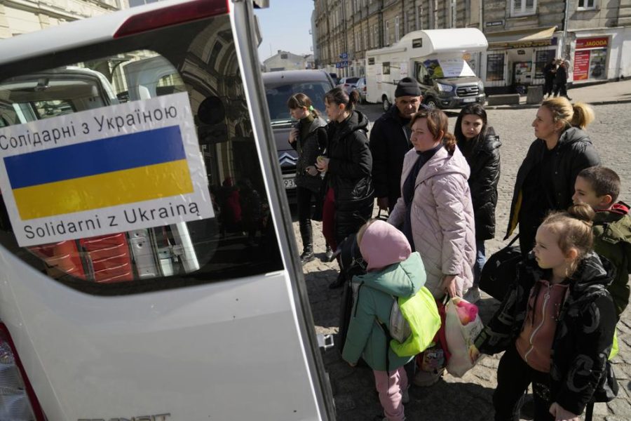 Ukrainian refugees with children board transport at a square next to a railway station in Przemysl, Poland, on Tuesday, March 22, 2022.