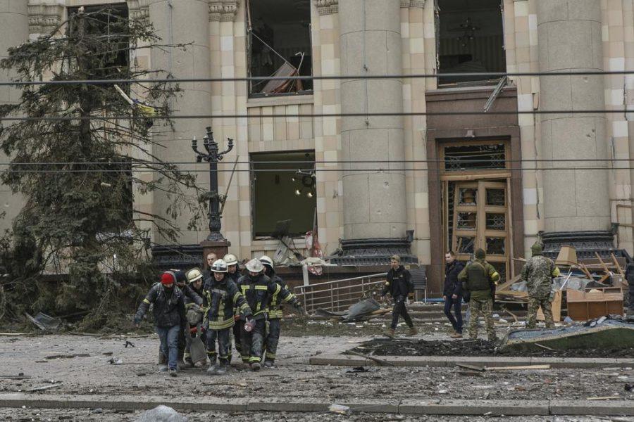 Ukrainian emergency service personnel carry the body of a victim following shelling of the City Hall building in Kharkiv, Ukraine