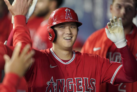 Los Angeles Angels Shohei Ohtani is greeted in the dugout after he hit a solo home run during the first inning of a baseball game against the Seattle Mariners, Sunday, Oct. 3, 2021, in Seattle. Ohtani, the Los Angeles Angels’ two-way superstar, is the winner of The Associated Press’ Male Athlete of the Year award.