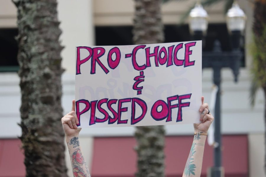 A protestor holds up a sign “The People’s Abortion Rally” for abortion rights in front of the Duval County Courthouse