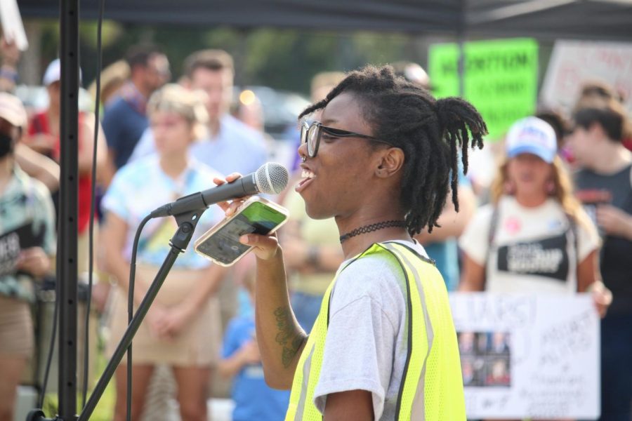 Tionna Jefferson speaks into a microphone during a rally