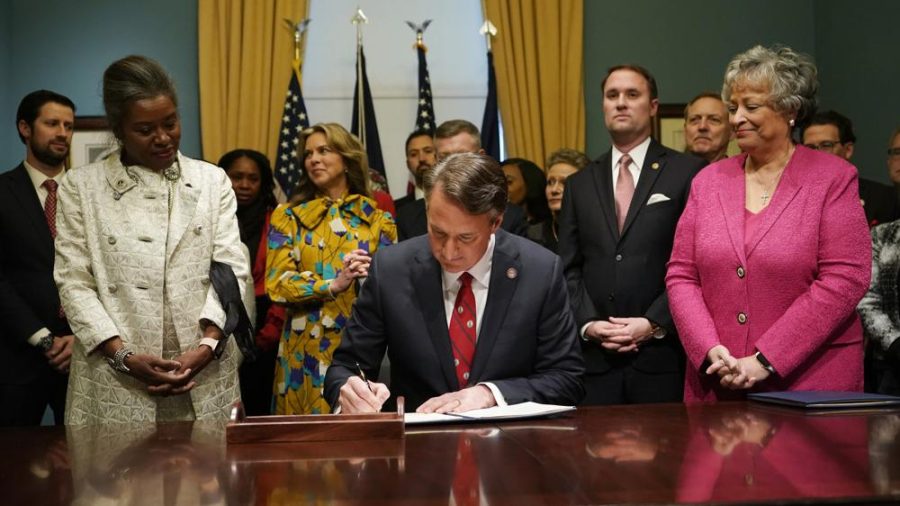 Virginia Gov. Glenn Youngkin, center, signs executive orders in the Governors conference room