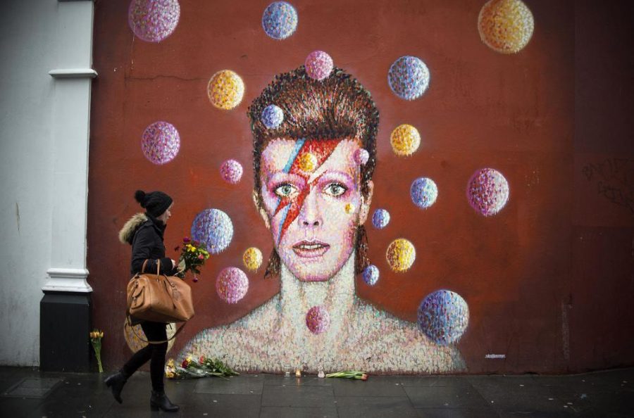 Flowers are left below a mural of David Bowie on the wall of a Morley's store in Brixton, London, the singer's birthplace, after the rock star died