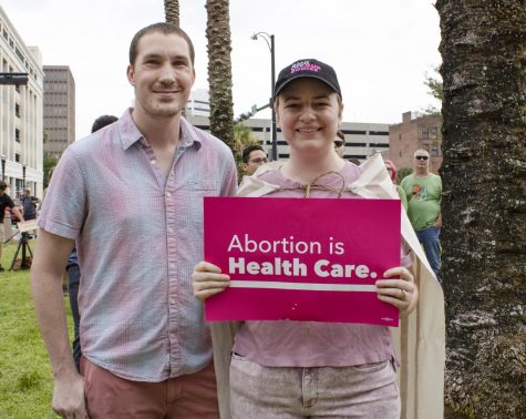 Two abortion rights protesters hold up a sign that says "abortion is healthcare"