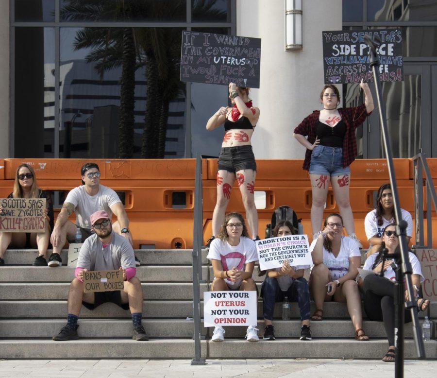 People sit on the duval county courthouse steps and hold signs