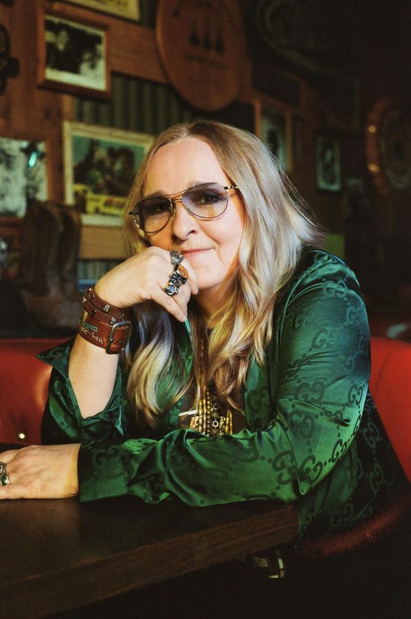 Wearing glasses, Melissa Etheridge looks at the camera for a photo
