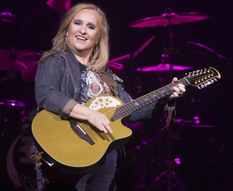 Melissa Etheridge performs in concert while singing and playing a guitar