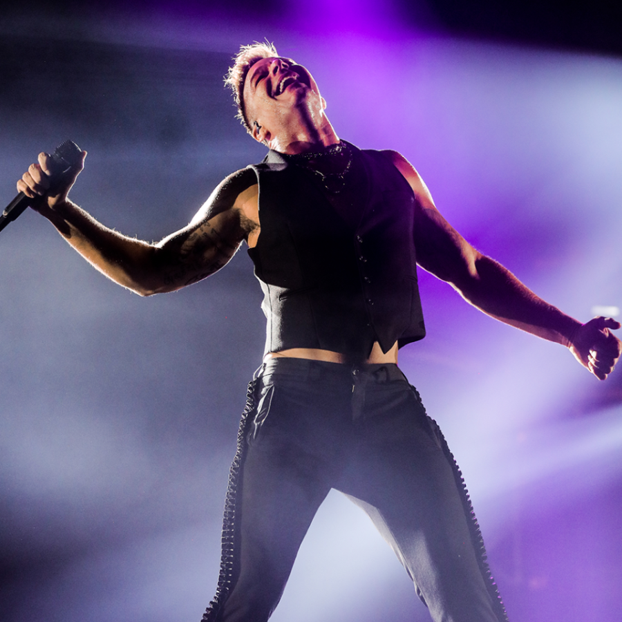 Ricky Martin smiles during a concert and holding a microphone