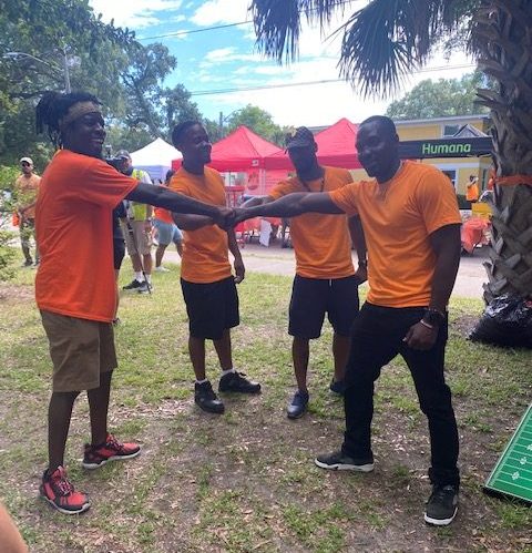 Volunteers put their hands together during a 'Wear Orange' park clean-up event