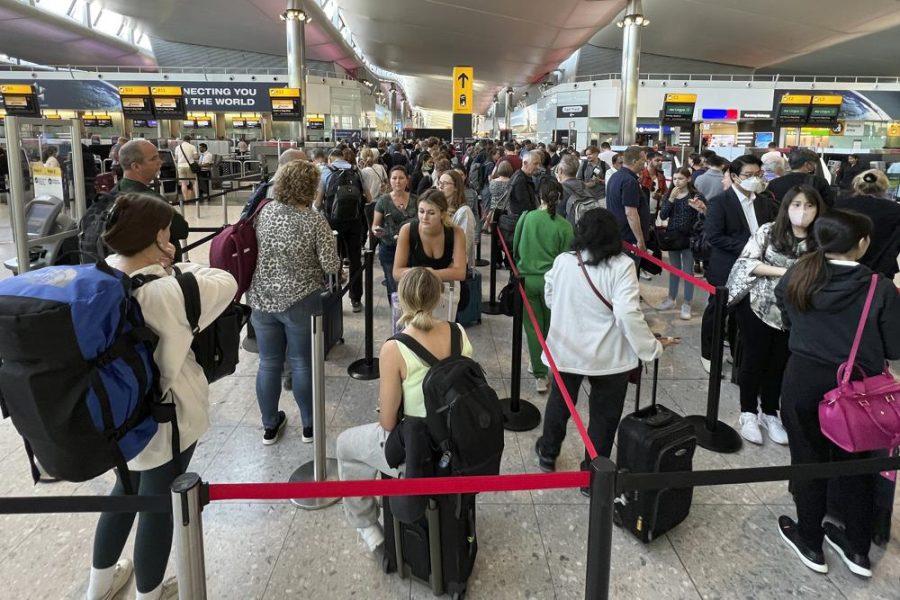 Travellers queue at security at Heathrow Airport in London