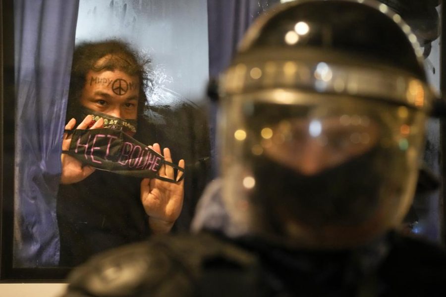 A detained demonstrator shows a sign No War! from a police bus in St. Petersburg, Russia, Thursday, Feb. 24, 2022. Hundreds of people gathered in Moscow and St.Petersburg on Thursday, protesting against Russias attack on Ukraine. Many of the demonstrators were detained. Similar protests took place in other Russian cities, and activists were also arrested. (AP Photo/Dmitri Lovetsky)