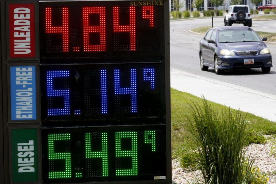 Gas prices listed at a gas station in red, blue and green in descending order