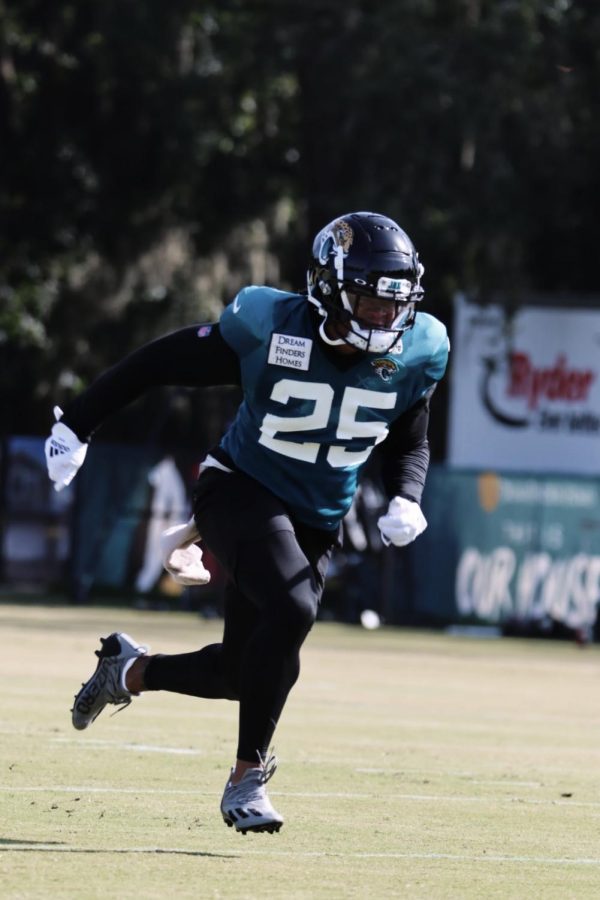 James Robinson in a green and black jersey running