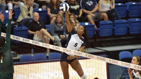 Mahalia White spikes volleyball over the net.