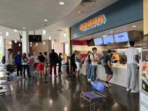 A crowd of 10 to 15 students stands in line for Qdoba.